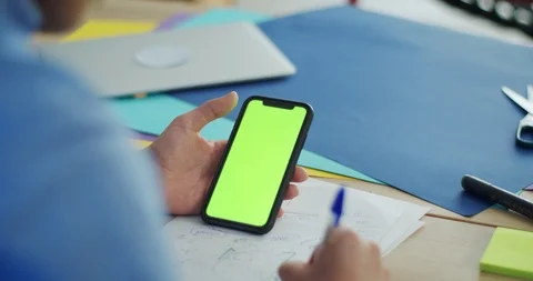 Close up of smart mobile device green display and guy making notes indoor office Stock Footage 124326009
