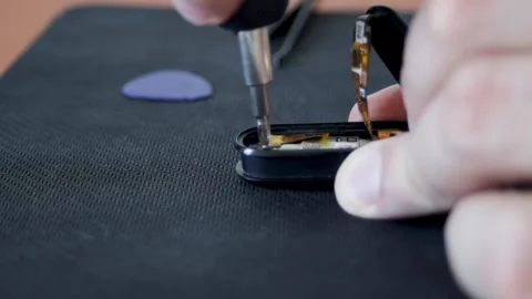 Close-up of a smart watch assembly with a screwdriver. Male hands in the frame Stock Footage 314996421
