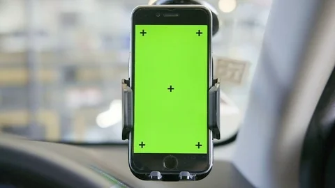 Close-up of smartphone with a green screen in the holder on windshield Stock Footage 116389451
