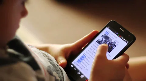 Close-up of a smartphone in the hands of a child Видео 36481333