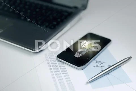 Close up of smartphone with lightbulb on screen Stock Photos