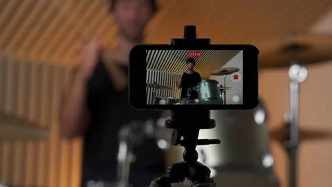 Close-up of smartphone. Man drummer creating online courses. Young male teaching Stockbeeldmateriaal 157793957