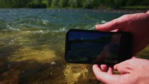 Close-up of smartphone recording river Stock Footage 334162367