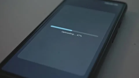 Close up of smartphone screen with file upload percentage bar finishing Stock Footage 341569705