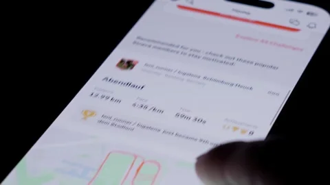 Close up of smartphone screen opening Strava fitness app as a finger taps Stock Footage 334161478