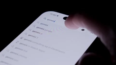 Close-up of smartphone screen showing app store search for Google Gemini, with Stock Footage 333928617