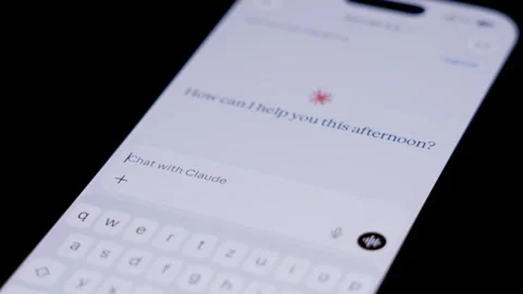 Close up of smartphone screen showing Claude AI app icon as a finger moves to 스톡 동영상 334161520