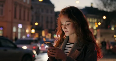 Close up of the smiled pretty young red haired woman typing and texting on the Stock Footage 100980980