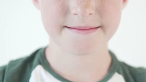 Close-up smiles of an 8-year-old boy with enamel damage on his lower tooth Stock Footage 134668336