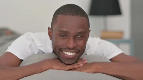 Close up of Smiling African Man Looking at Camera in Bed Stock Footage 287901257