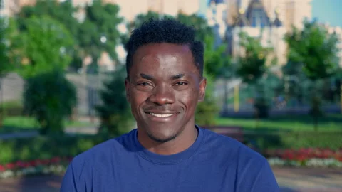 Close up smiling afro-american man looks camera on background park in summer Stock Footage 158351539