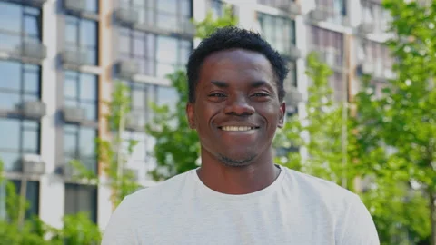 Close up smiling afro-american man looks camera on background modern building Stock Footage 159010323