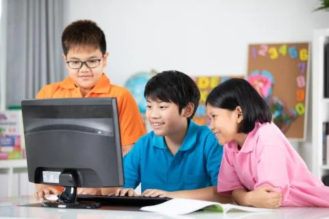 Close up of Smiling asian pupils using a desktop computer. Foto stock