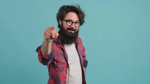 Close up of smiling bearded man pointing at you over turquoise background. Stock Footage 140589631