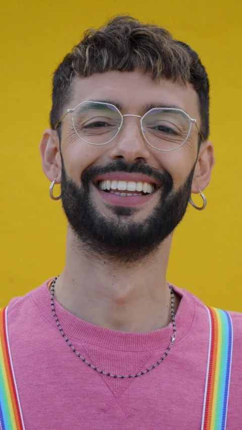 Close up smiling cheerful young Caucasian man with rainbow lgbt suspenders Stock Footage 276868308