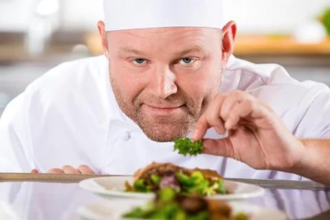 Close-up of smiling chef prepare steak dishes at restaurant Stock Photos