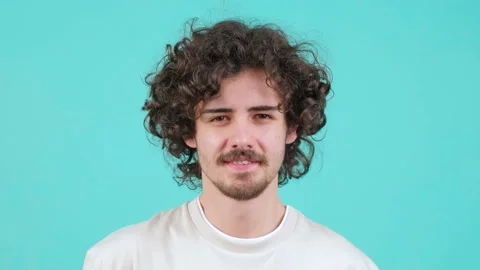 Close up of a Smiling curly haired man offering wrapped box to camera. Stock Footage 156048158