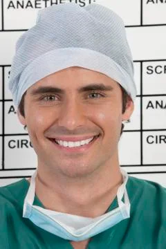 Close up of smiling doctor in front of schedule board in hospital Stock Photos