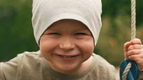 Close-up smiling face of little cute baby during swinging on swing posing Stock Footage 110707679