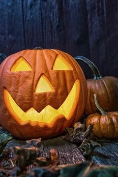 Close-up of a smiling Jack O' Lantern and pumpkins at night Foto stock