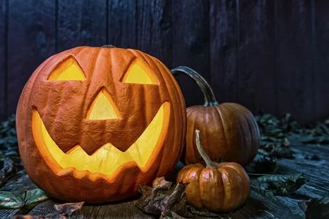 Close-up of a smiling Jack O' Lantern and pumpkins at night Foto stock