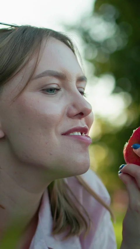Close Up of Smiling Lady Taking a Bite from Red Apple Outdoors Stock Footage 317584209
