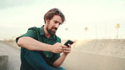 Close-up of smiling man with a beard chatting on the embankment background Stock Footage 226888857