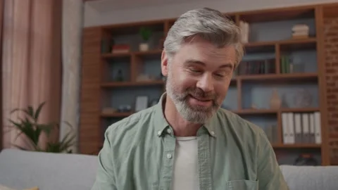 Close up smiling man having video call while sitting at home on sofa. Blogger Vídeos de archivo 220202881