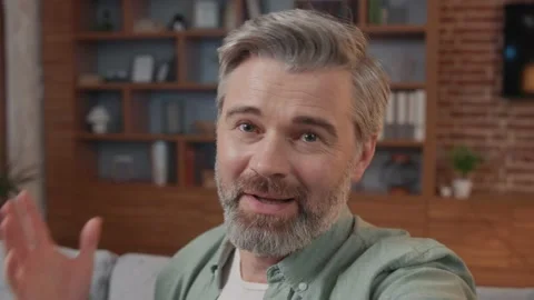 Close up smiling man making selfie or video call while sitting at home on sofa Vídeos de archivo 220202860