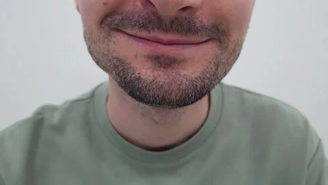 Close-up of a smiling man with a short beard wearing, lightly chewing Stock Footage 284043632