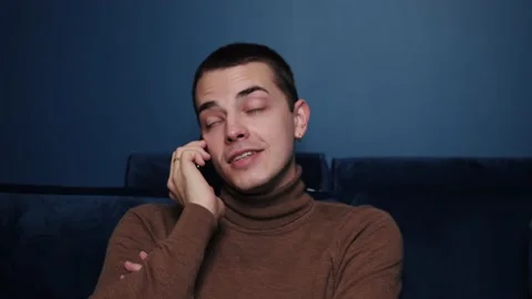 Close up smiling man talking mobile phone on sofa at home. Close up of cheerful Stock-Footage 144311835