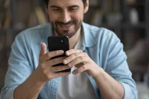 Close up smiling man using smartphone, browsing mobile device apps Stock Photos