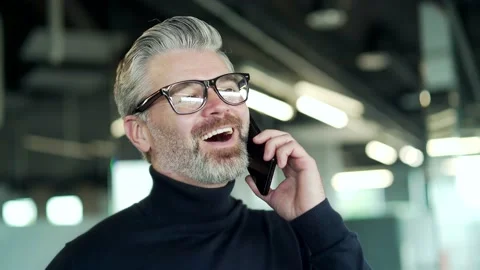 Close up of smiling mature gray haired bearded man in glasses talking on smart Stock Footage 232578535