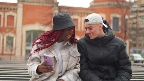 Close-up of smiling multi-ethnic couple in the street having a video conferen Stock Footage 219886957