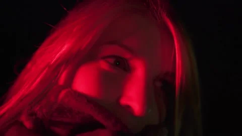Close up of smiling pretty blonde face in red light Stock Footage 144671745