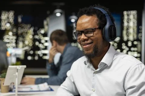 Close up of smiling software developer wearing headphones doing code testing Foto stock