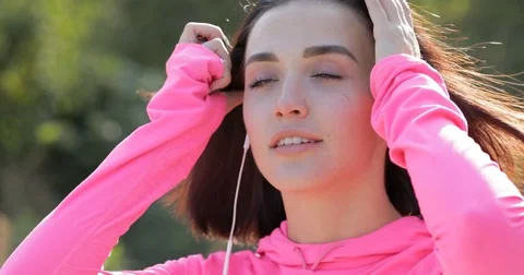 Close up of smiling sportswoman knotting hair before jogging Stock Footage