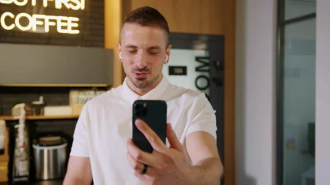Close-up of a smiling young man during a video call on the phone with partners Stock Footage 195207372