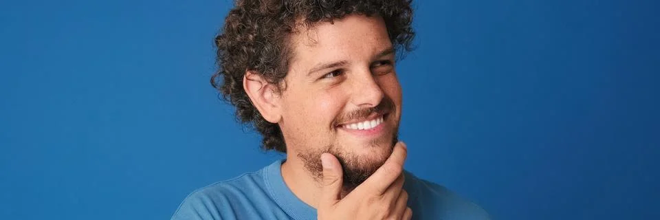 Close up, Smiling young man thinks over his interesting idea, remembering s.. 库存照片