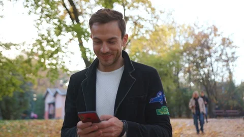 Close up smiling young man use phone walk happy in the park grass telephone Stock Footage 102738990