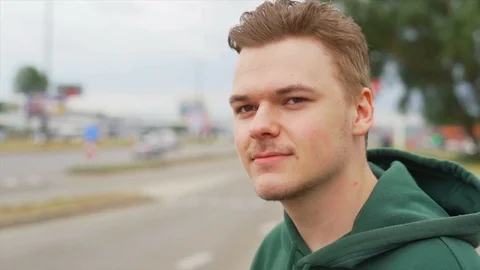 Close up of A smiling young man who is staring away from camera near the traffic Stock Footage 91230970