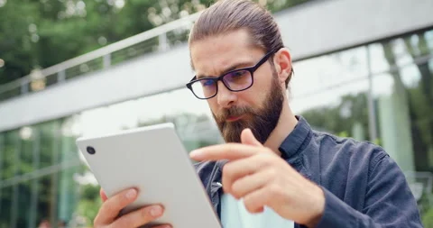Close-up of a smiling young professional man using a digital tablet outdoors nea Stock Footage 330955094