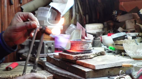 Close-up of smith using gas burner to make bracelet, jewelry market in Tunis Stock Footage 334377710