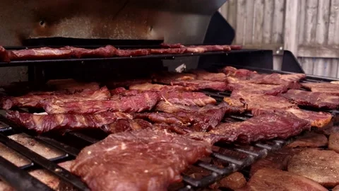 Close up of smoked and dehydrated beef jerky cooling in custom modified grill Video stock 163240887