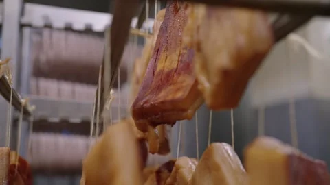 Close up of smoked bacon hanging in a processing facility, traditional cured Video stock 333348919