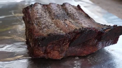Close-up of Smoked BBQ Beef Short Ribs on Aluminum Foil Stock Footage 338212436