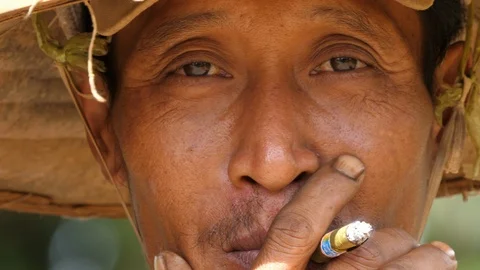 Close-up of a smoking Burmese with hat in 4K Stock Footage 94921986