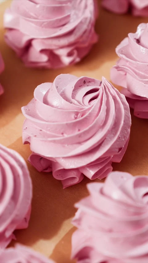 Close up of smooth glossy light purple pink meringue cookie with small specks on Stock Footage 344417899