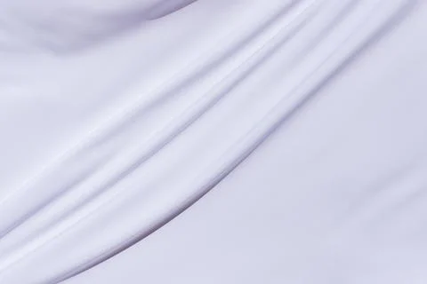 Close-up of smooth white fabric with diagonal folds, perfect for textile Stock Photos