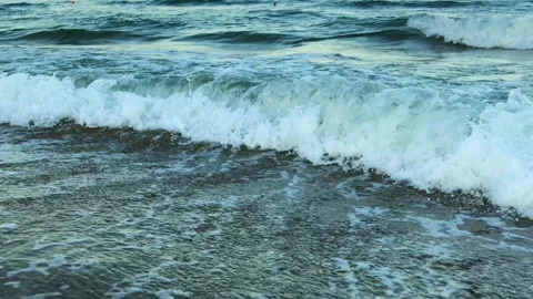 A close-up of smoothly walking into the waves while they crash on the shore Stock Footage 135172475